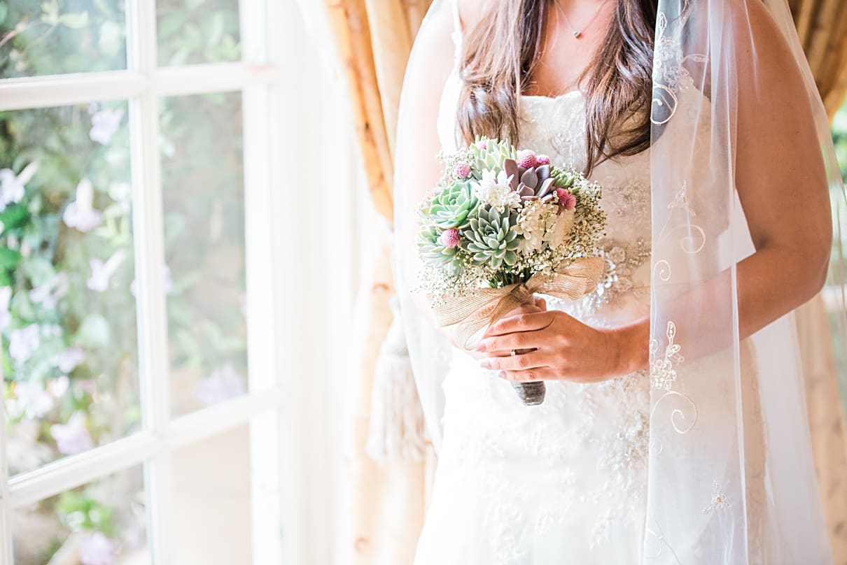 bride by window with succulent bouquet
