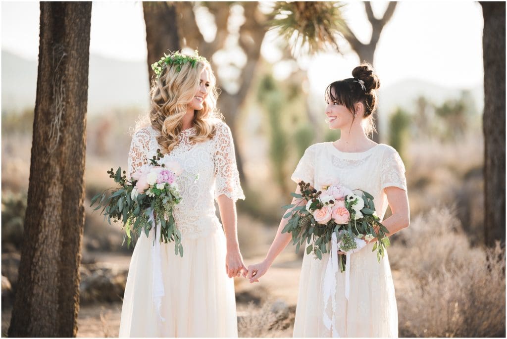two brides holding hands in the desert