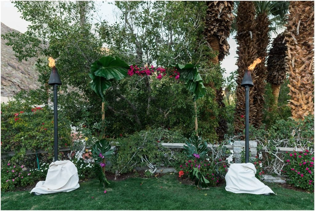 tropical wedding arch with monsera leaves and bougainvillea