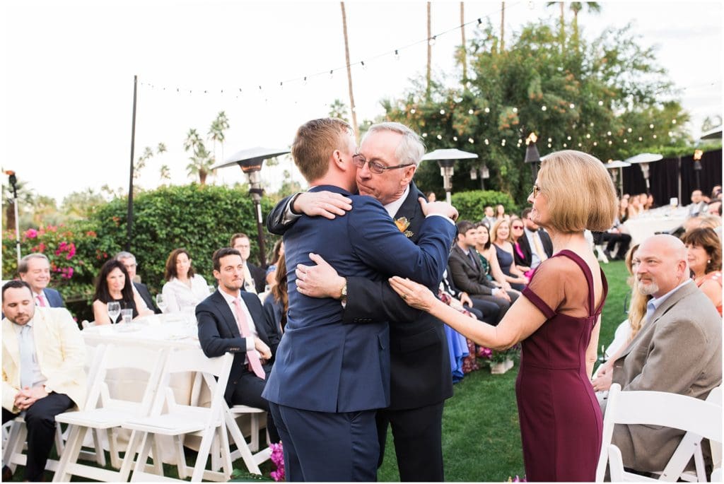 groom hugging his parents at wedding ceremony