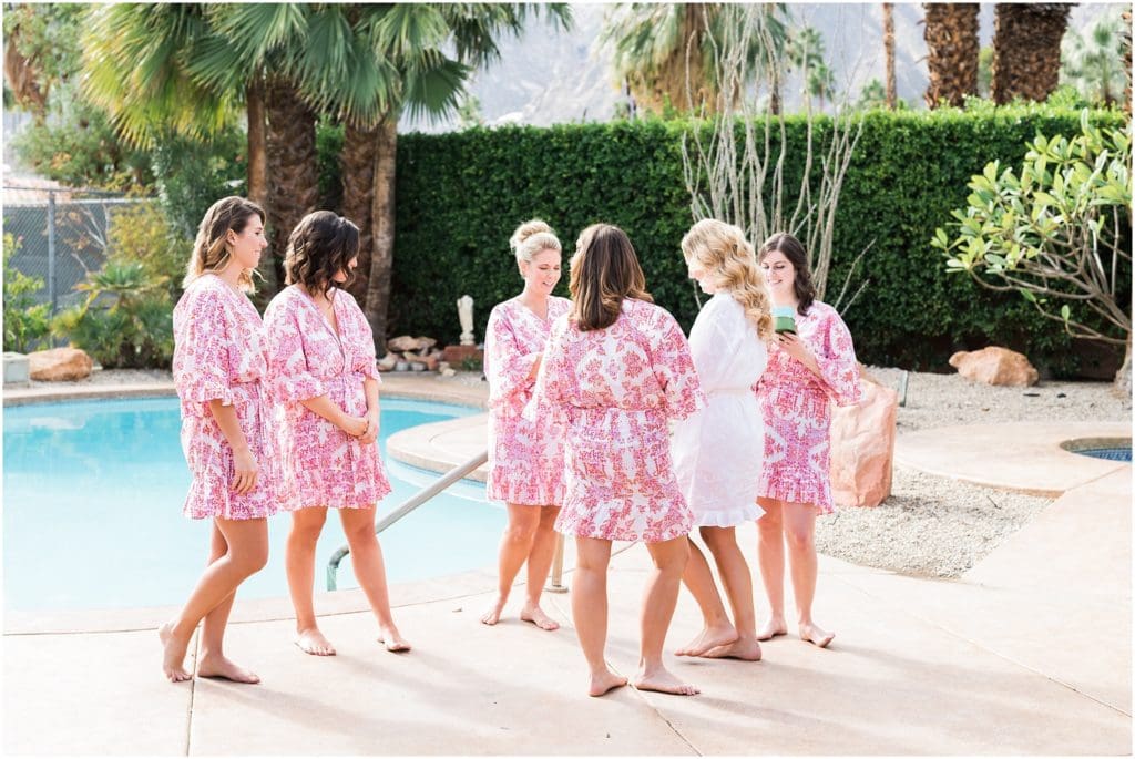bride giving bridesmaids gifts in pink robes