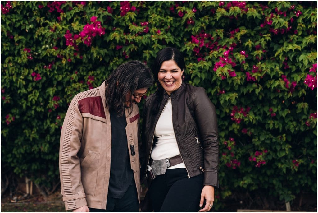 couple laughing in front of bougainvillea