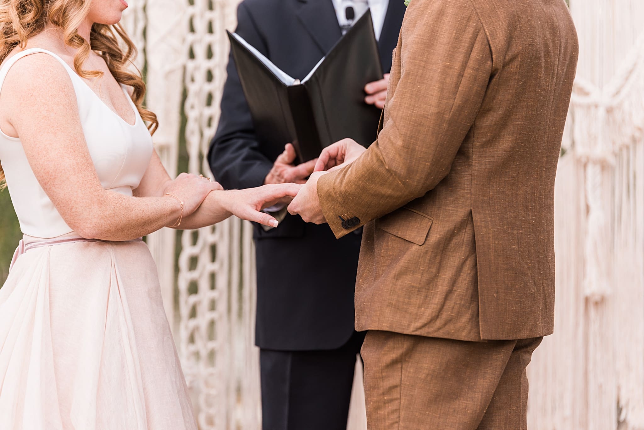 groom placing ring on bride's finger