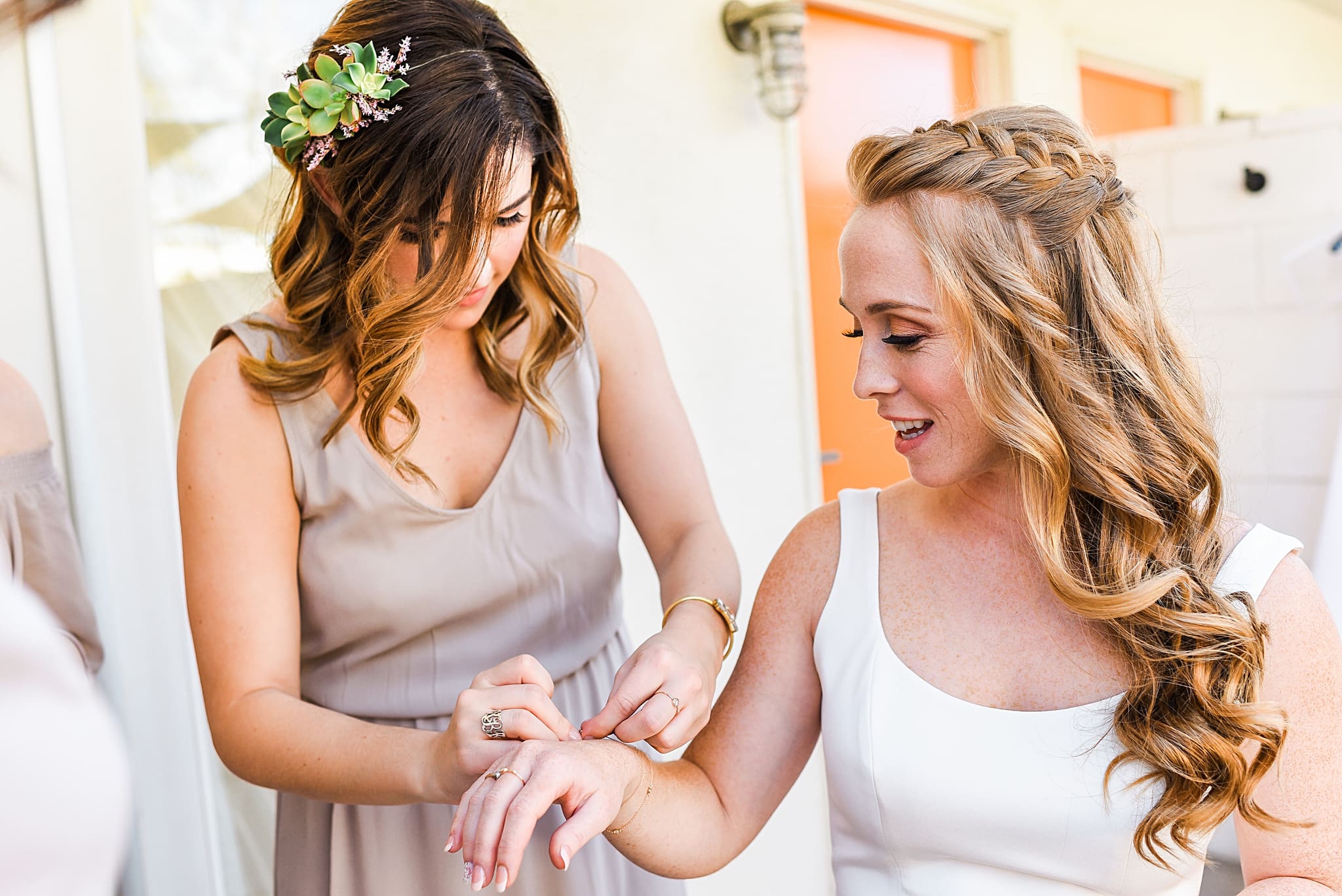 bridesmaid putting bracelet on bride