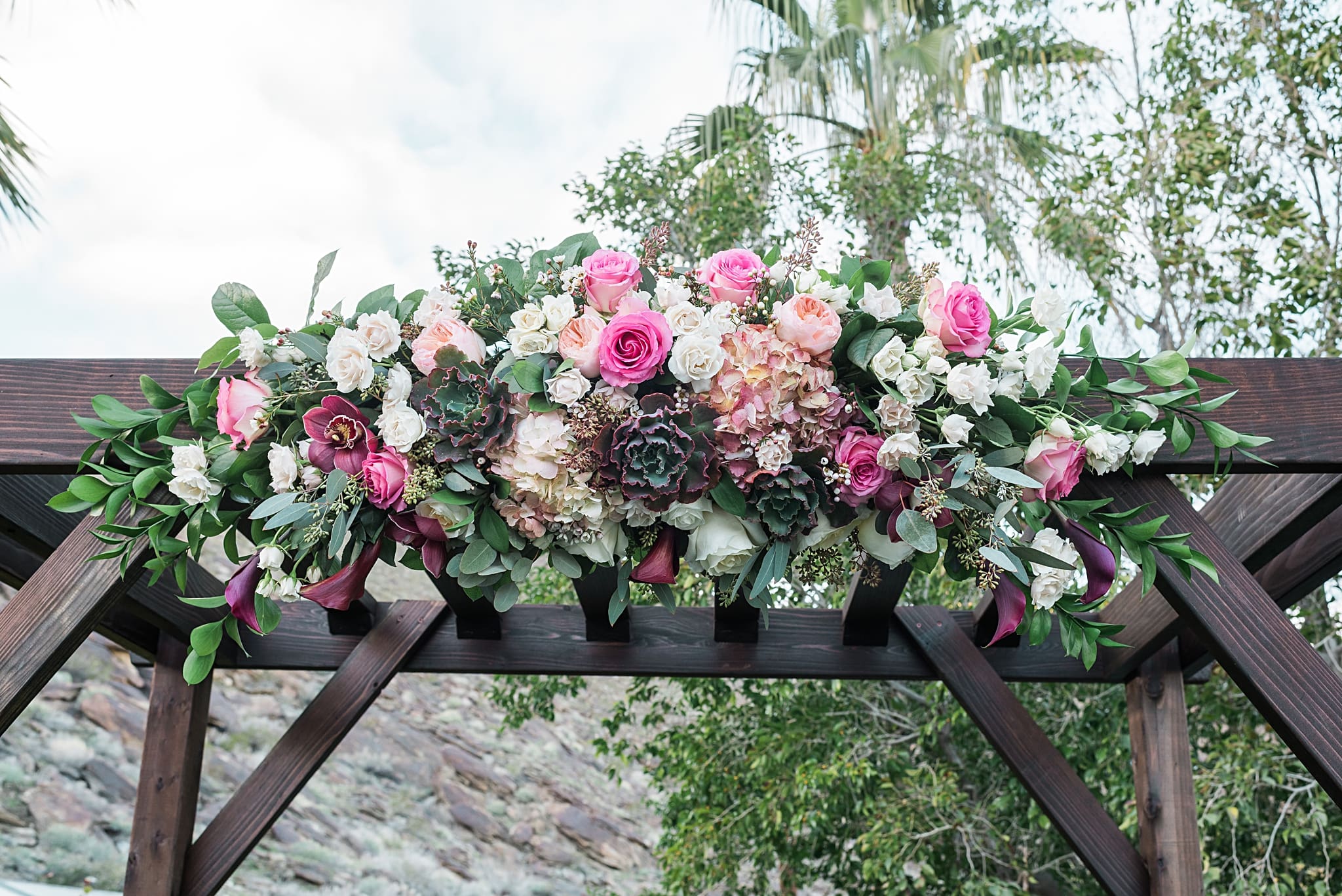 pink flowers on wedding arch
