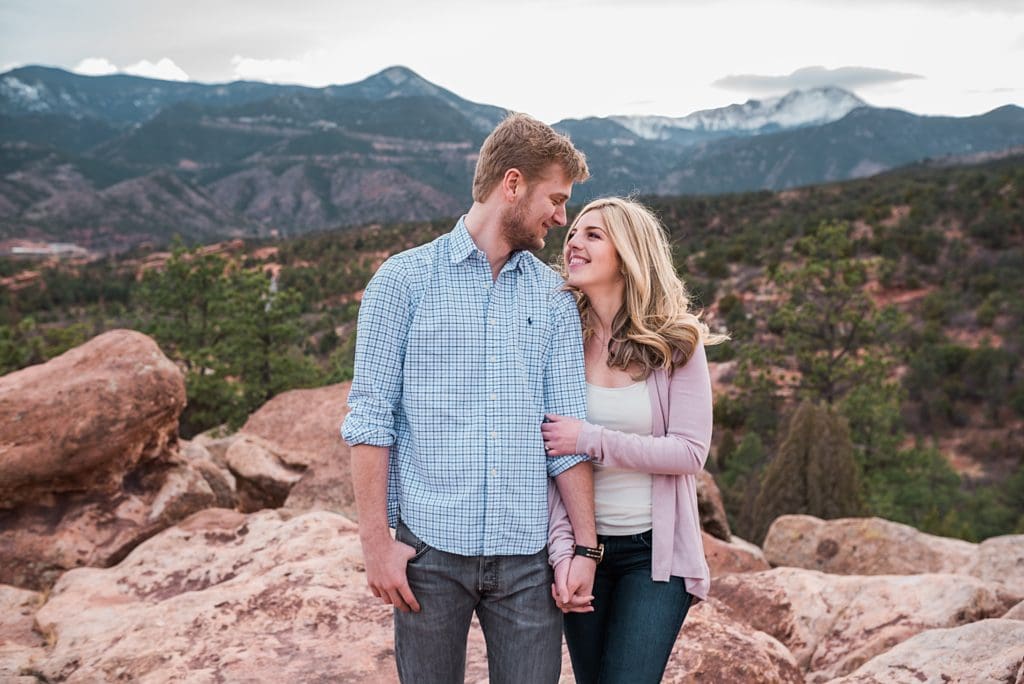 couple walking hand in hand at engagement session at garden of the gods