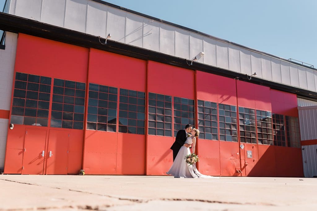 wedding couple in front of hangar doors