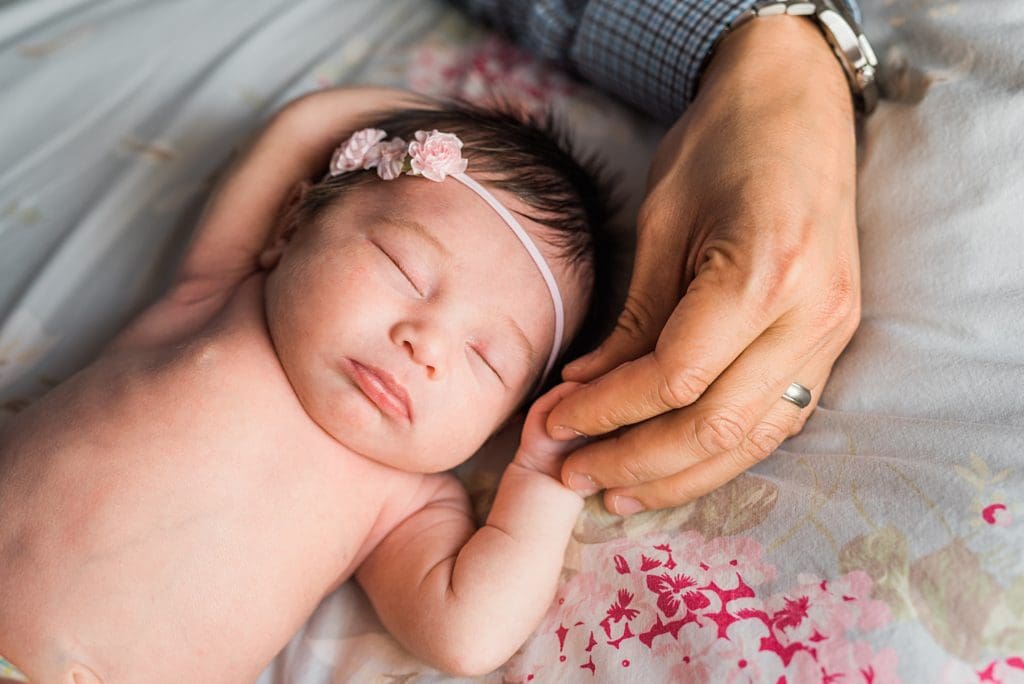newborn baby girl holding daddy's finger
