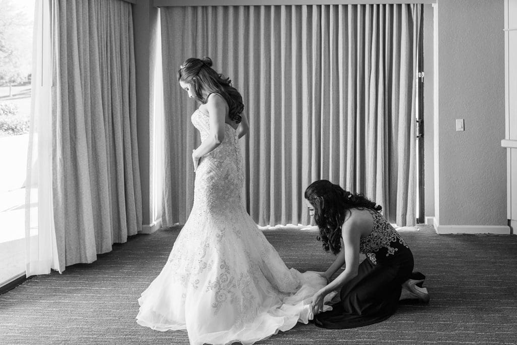 sister helping bride get dressed