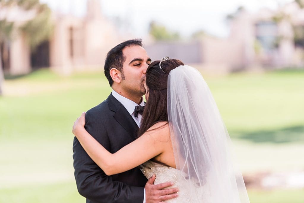 groom kissing bride on the forehead