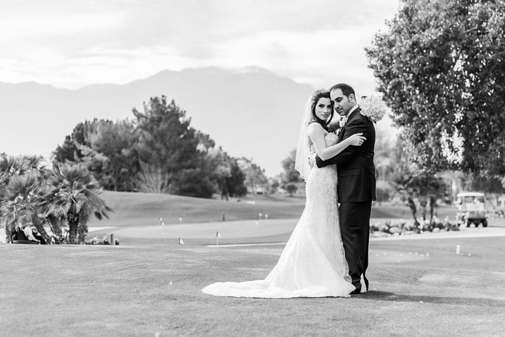 bride and groom snuggling on the golf course