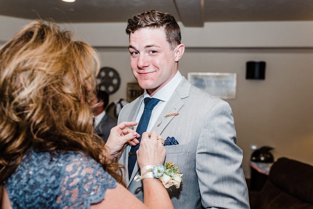 groom's mom putting boutonniere on