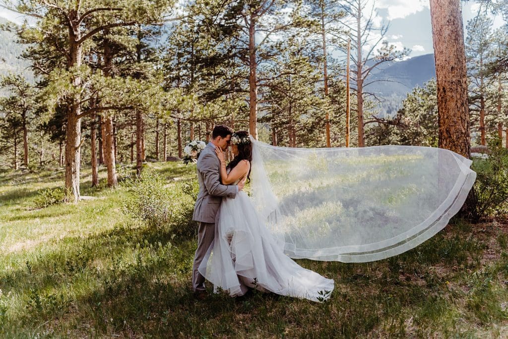 bride and groom kissing with veil in the wind