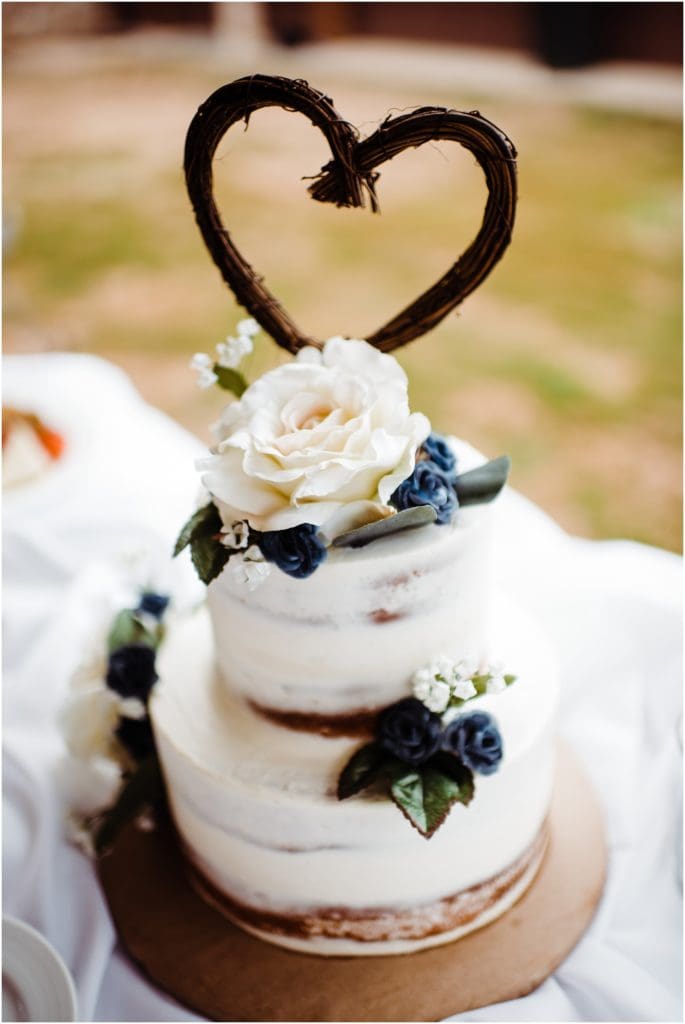 rustic naked wedding cake with a wicker heart topper