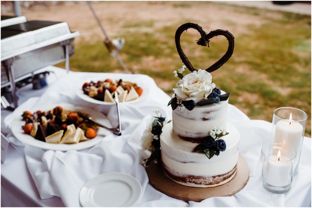 rustic naked wedding cake with a wicker heart topper