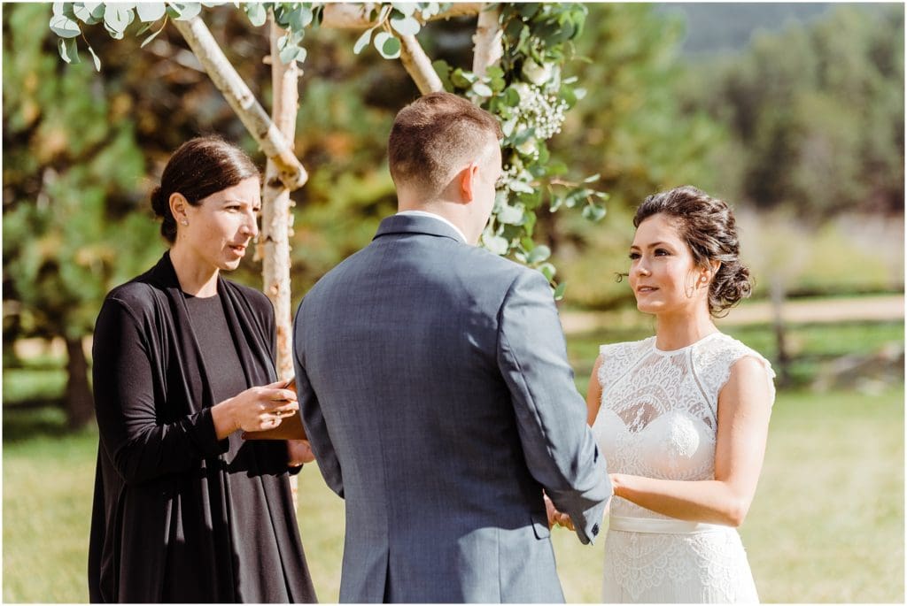 exchanging vows under rustic arch