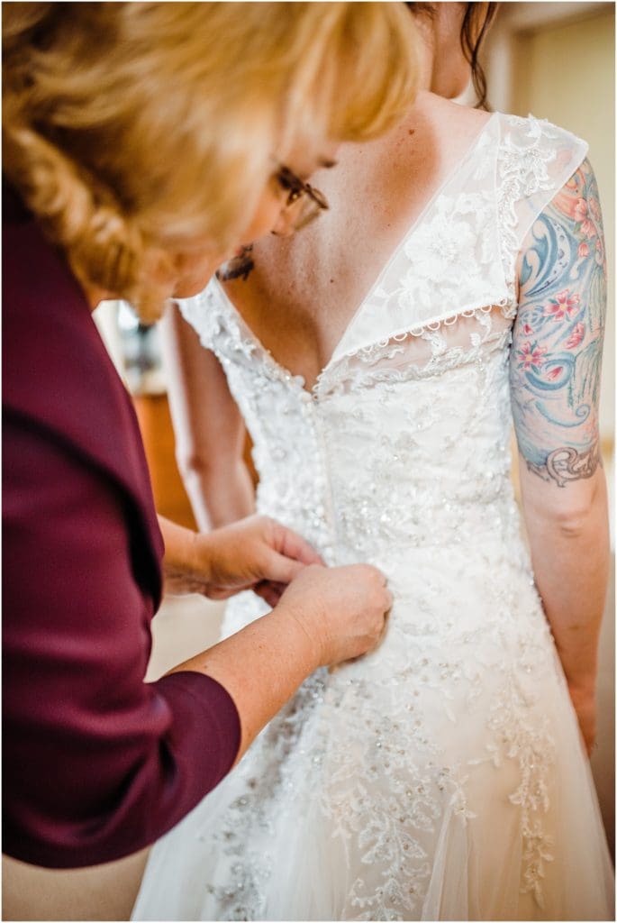 bride zipping up her dress