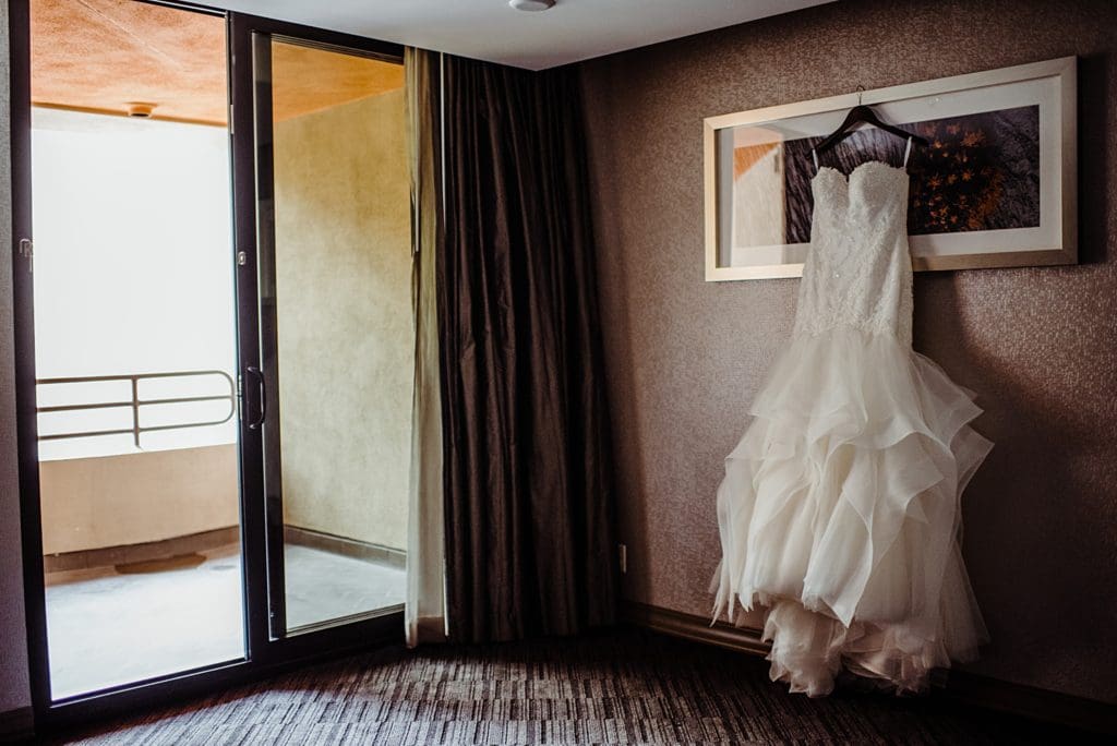 wedding dress hanging up in hotel room