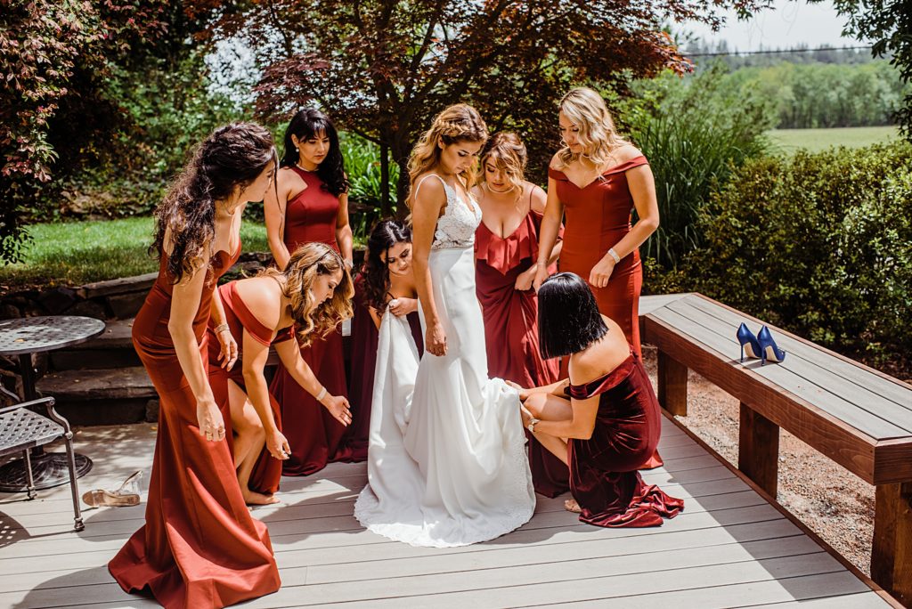 bridesmaids helping brides get dressed