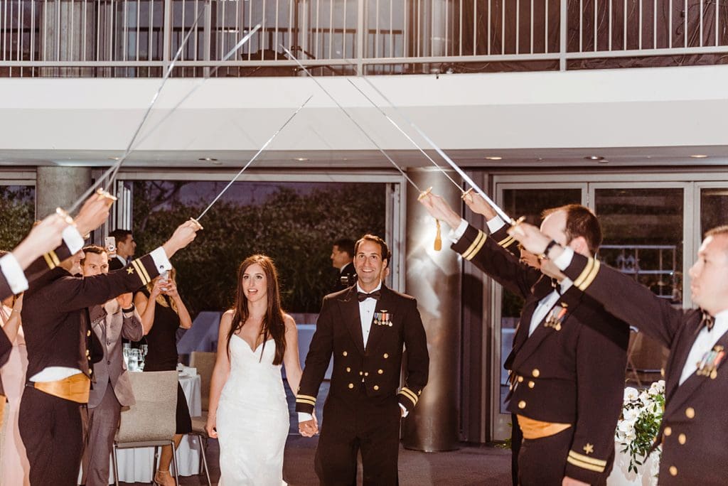 arch of sabers at navy wedding reception