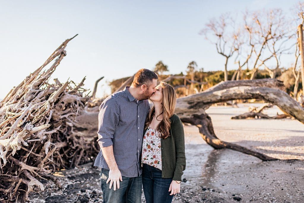husband and wife kissing at driftwood beach