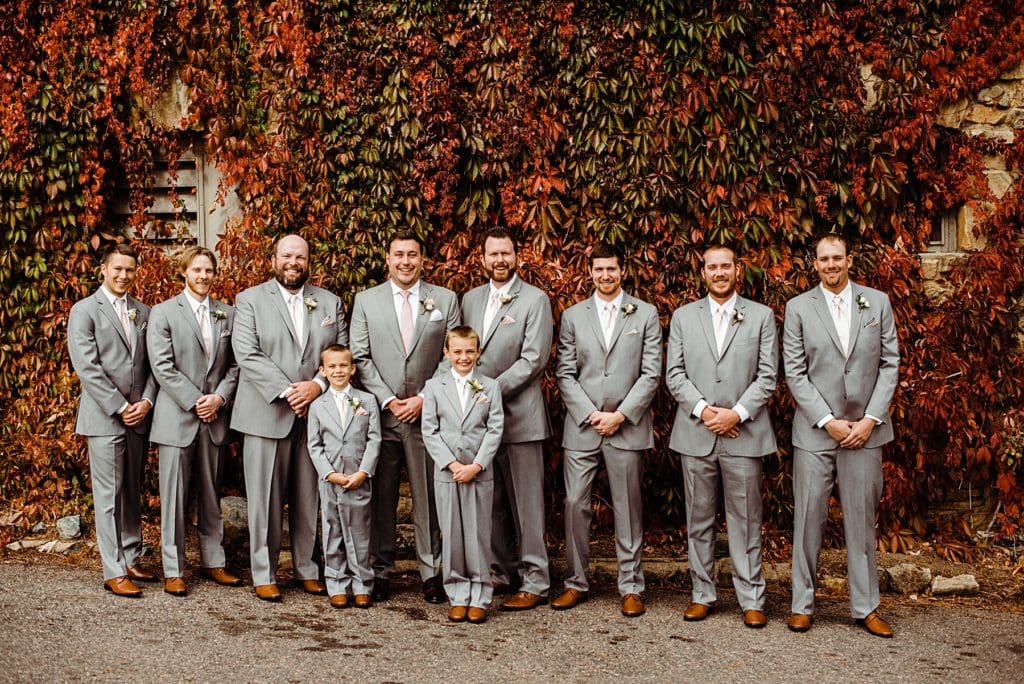 groom party in front of fall colored wall