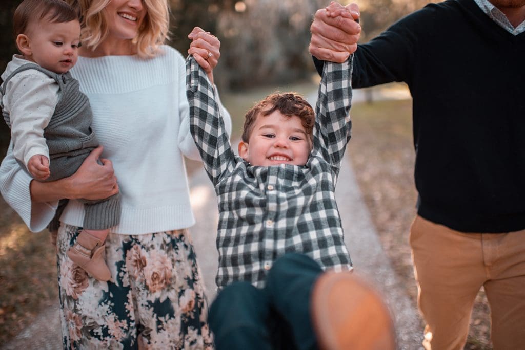 little boy swinging with his parents