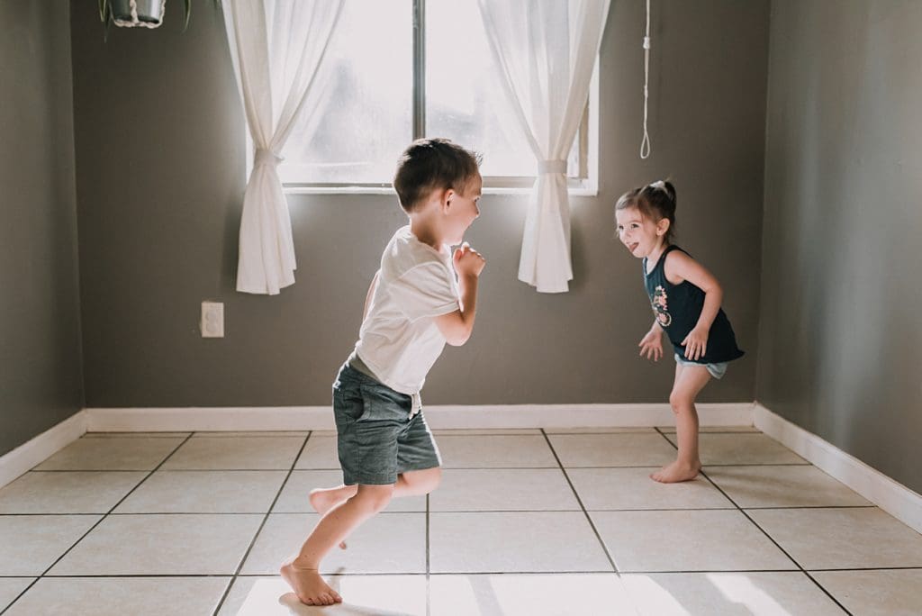 two kids playing in the kitchen