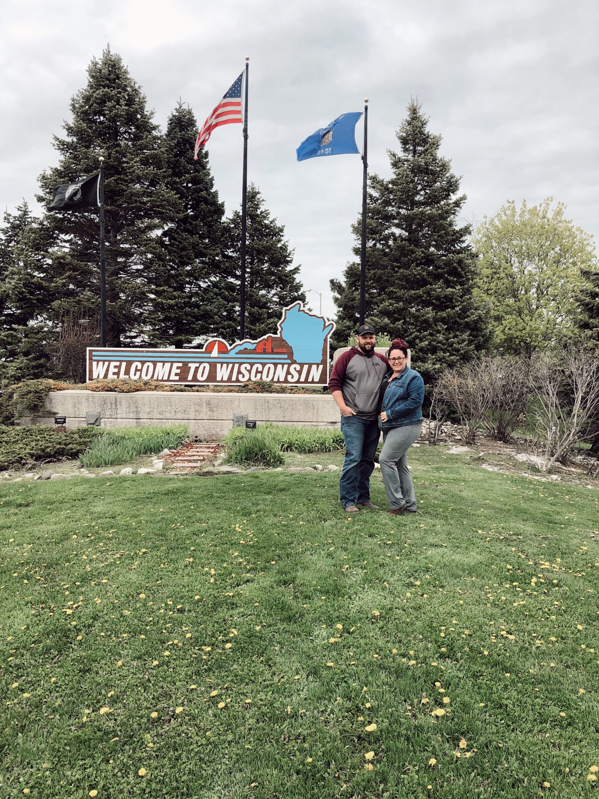 family in front of wisconsin sign