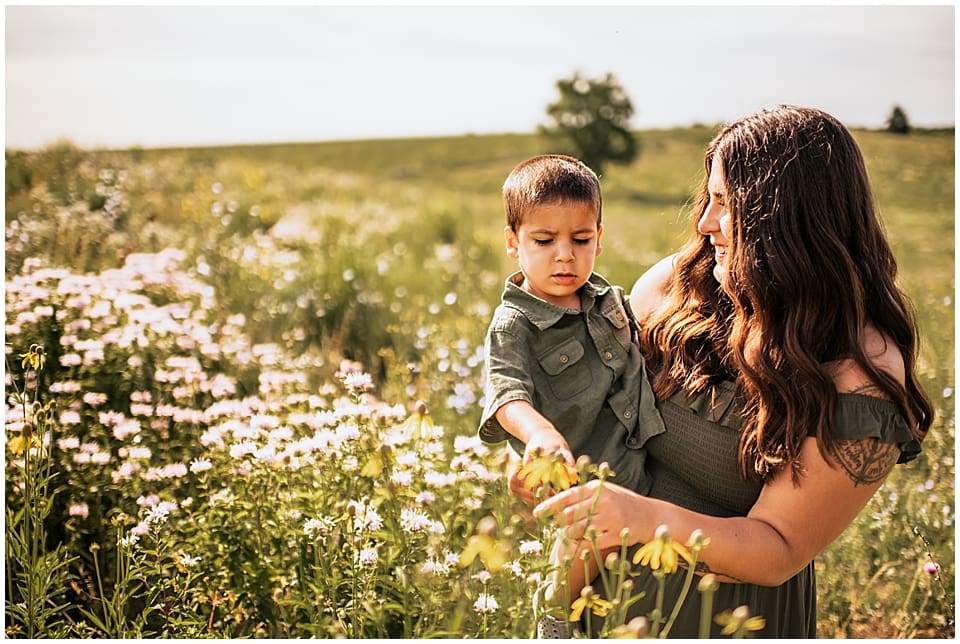 little boy held by mom looking at wildflowers