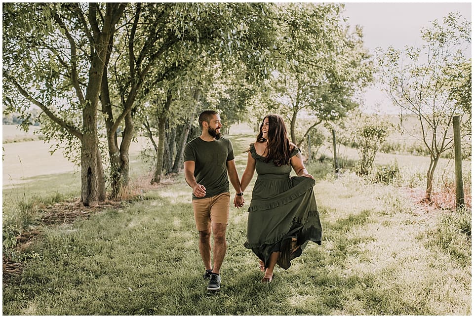 couple running together in a grove of trees
