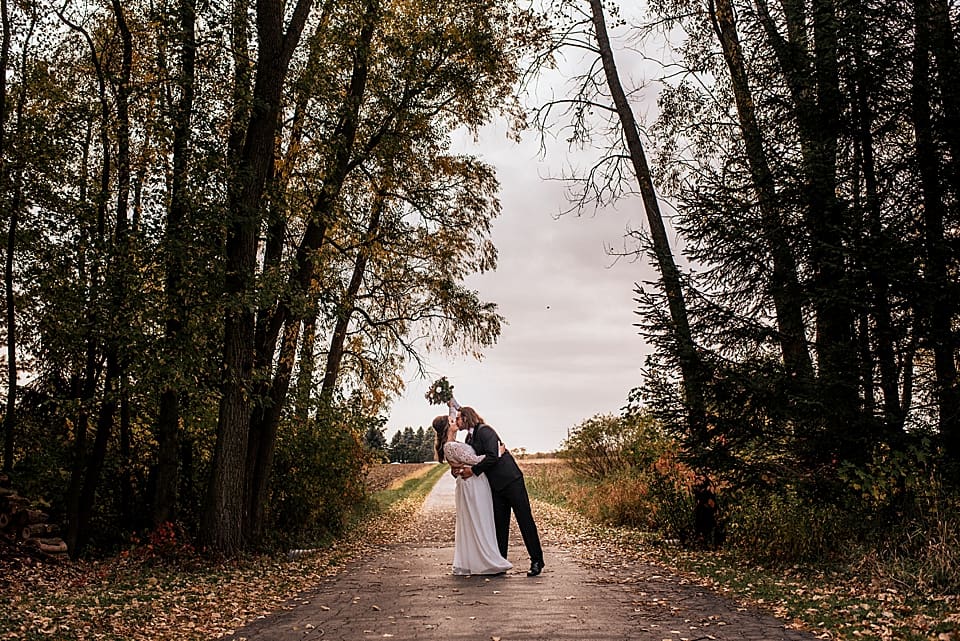 couple kissing on a wooded road