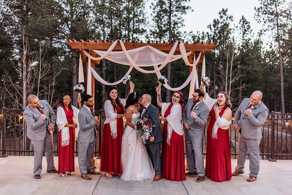 wedding party cheering on kissing newlyweds