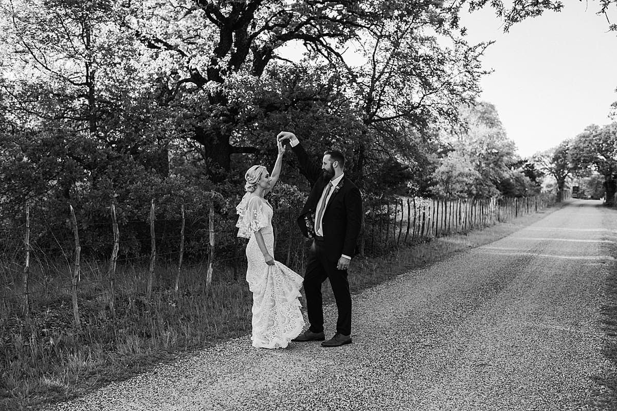 bride and groom dancing together on a texas dirt road