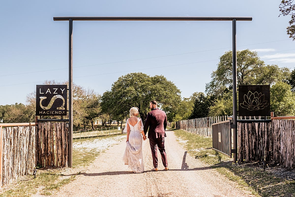 bride and groom walking down a dirt path at a texas ranch wedding