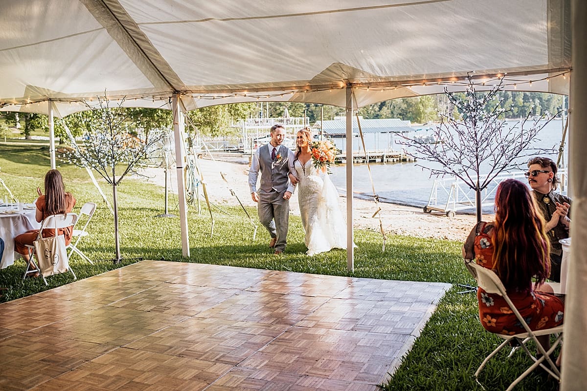 bride and groom entering tented reception