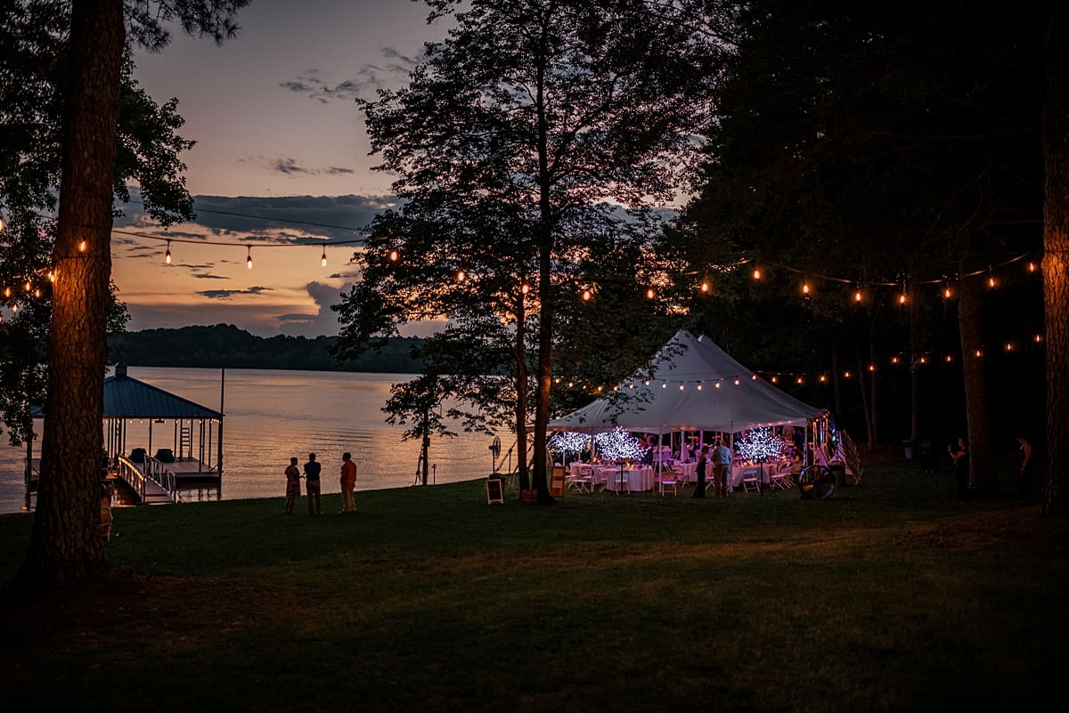lakeside wedding reception with a tent and string lights