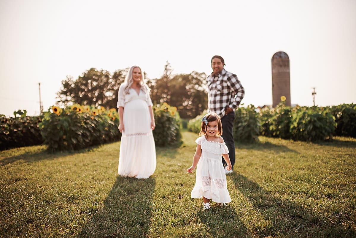 family of three in sunflower field