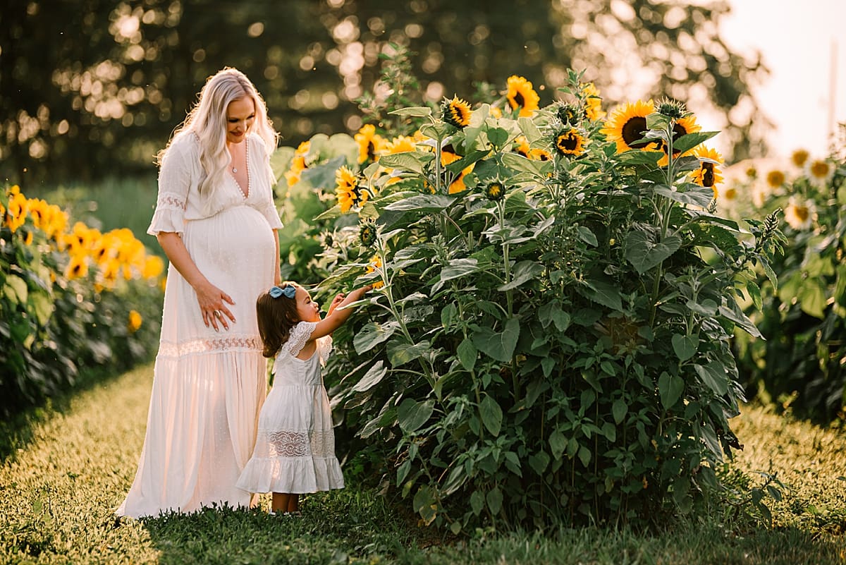 mother and toddler in sunflower field