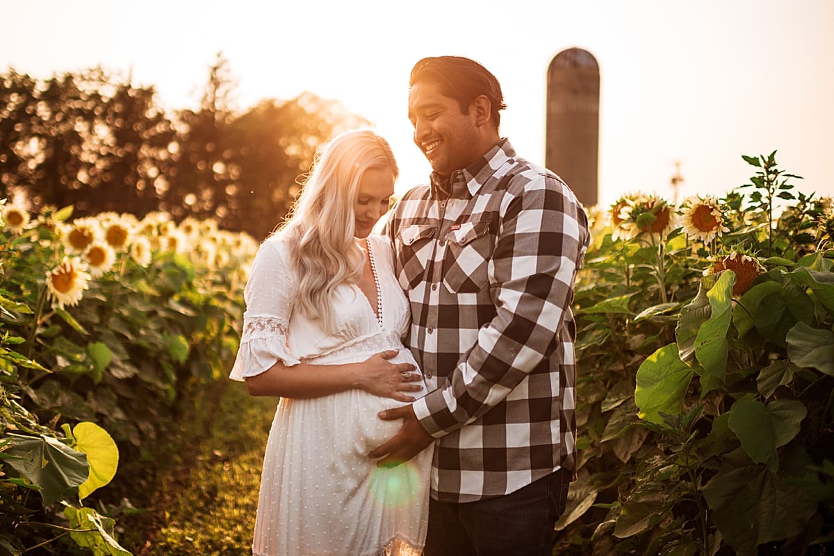 maternity photos at a sunflower field at sunset