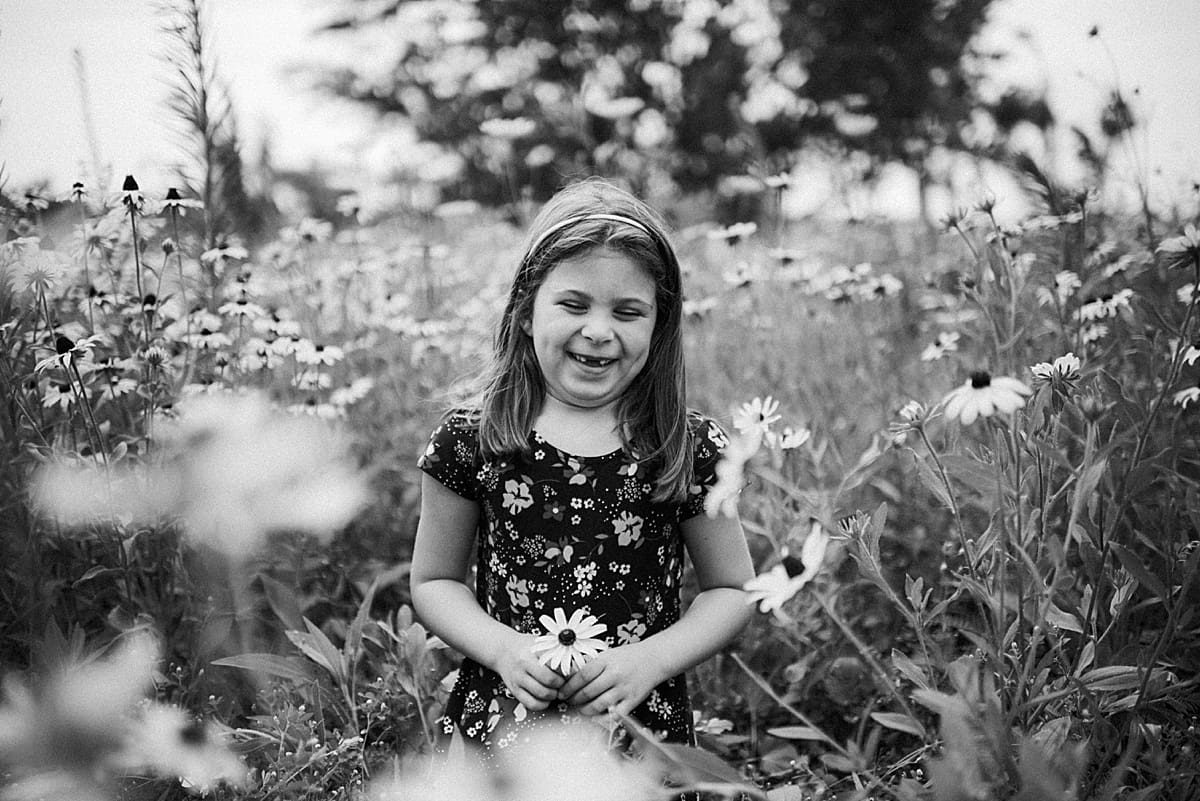 little girl in field of flowers