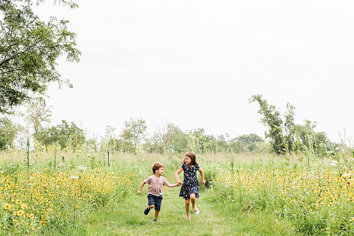 two kids running through a field of flowers