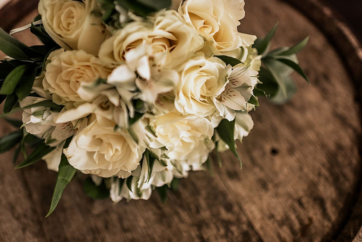 white bridal bouquet on a whiskey barrel