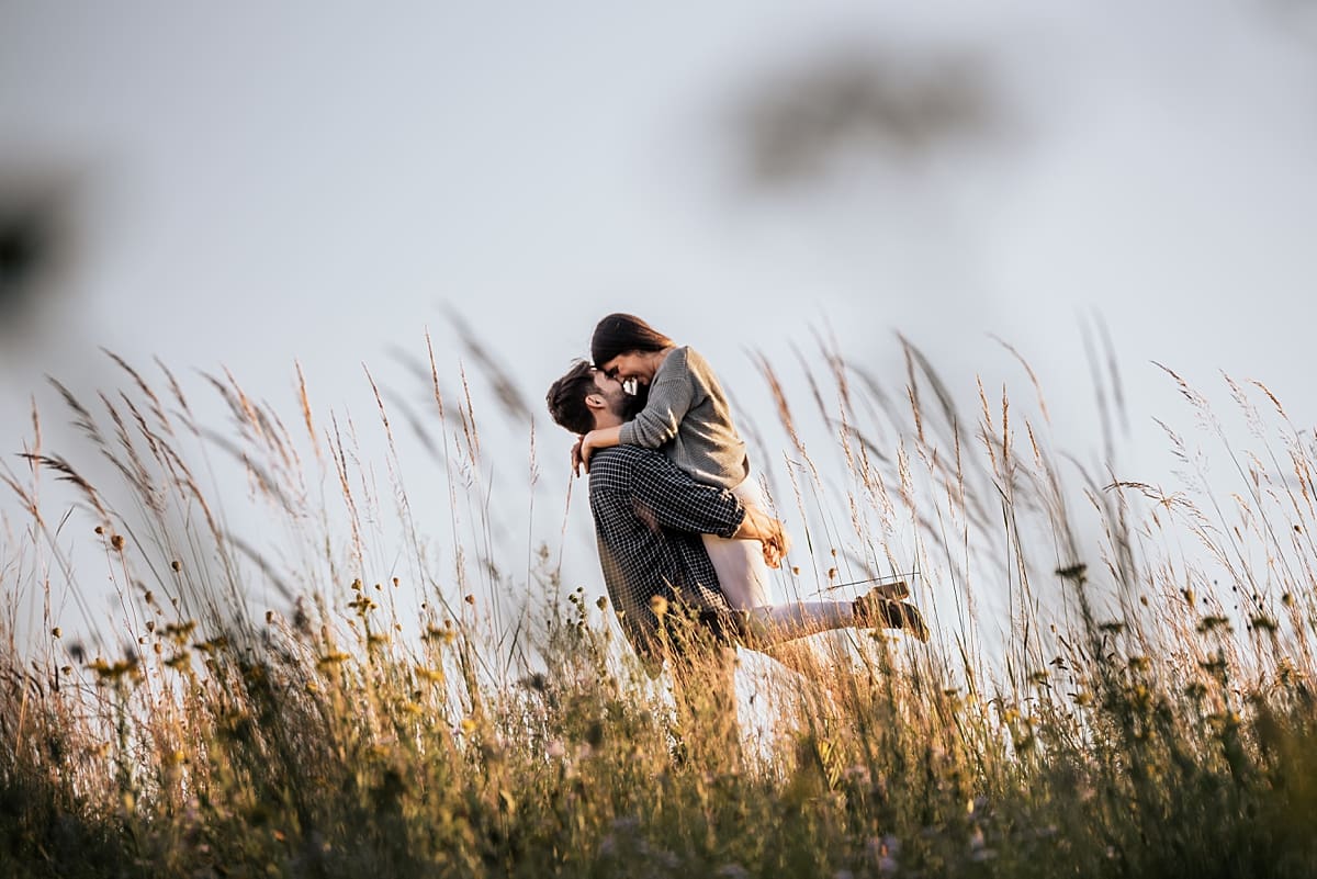 engaged couple walking together through a field of wildflowers at white river county park
