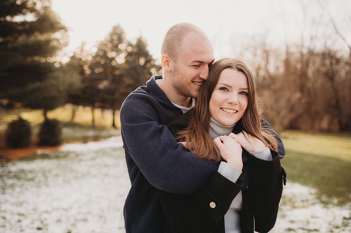 man whispering in fiance's ear for engagement session