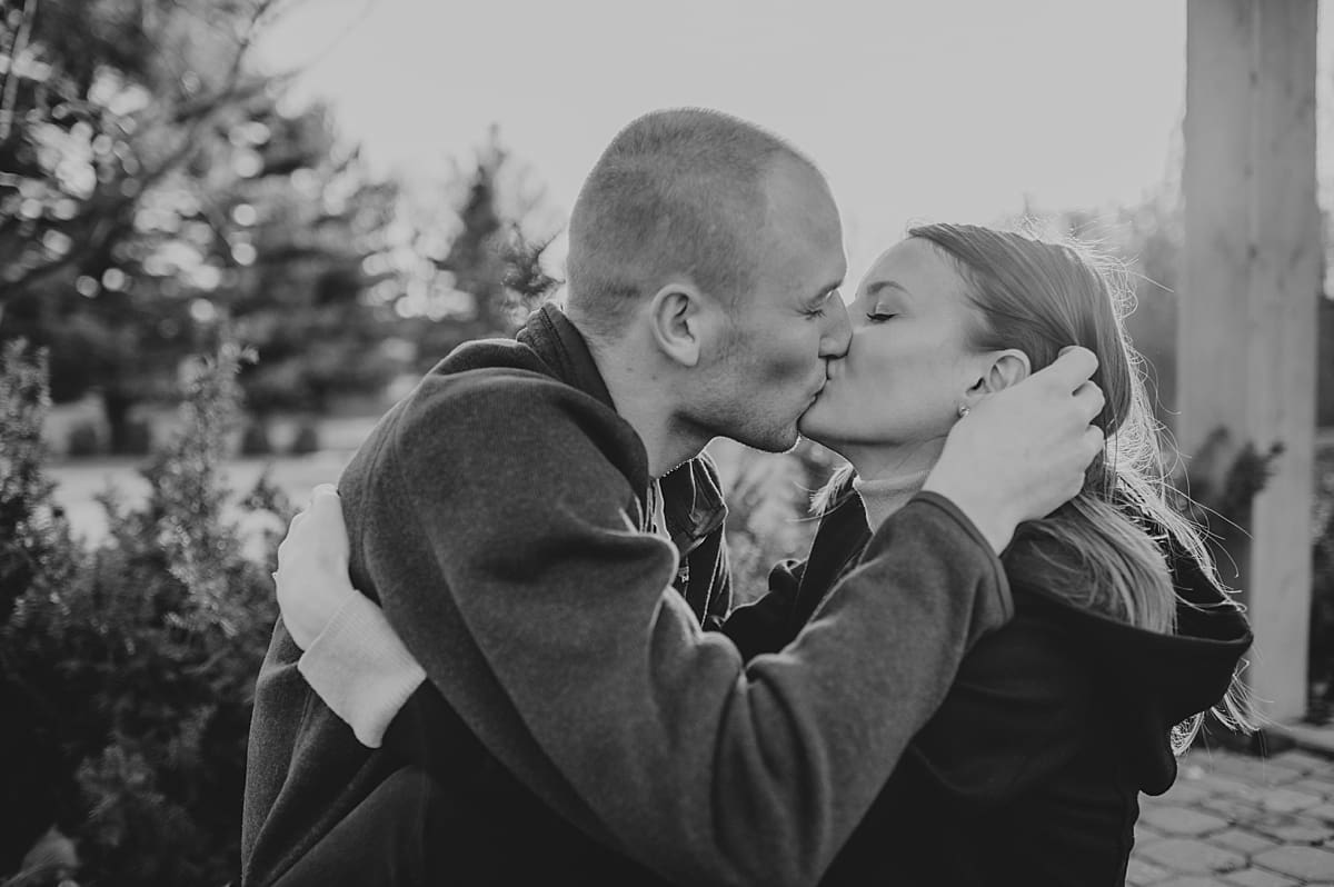 man tucking hair behind fiance's ear before kiss