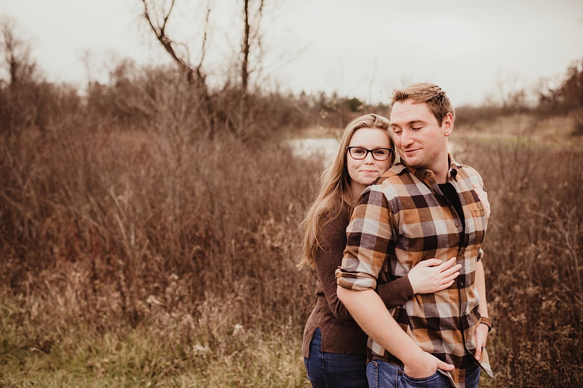 engagement session pose with woman hugging fiance from behind