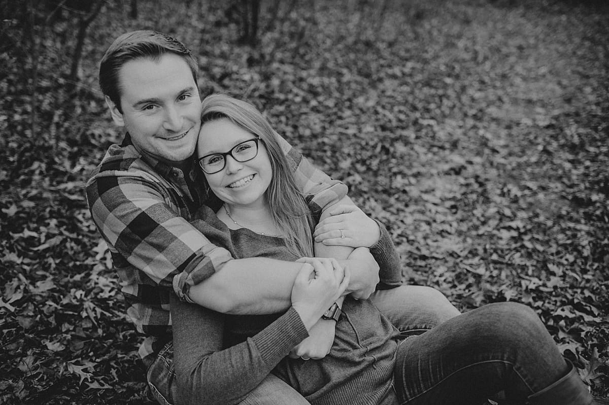 black and white engagement photo of couple in the leaves