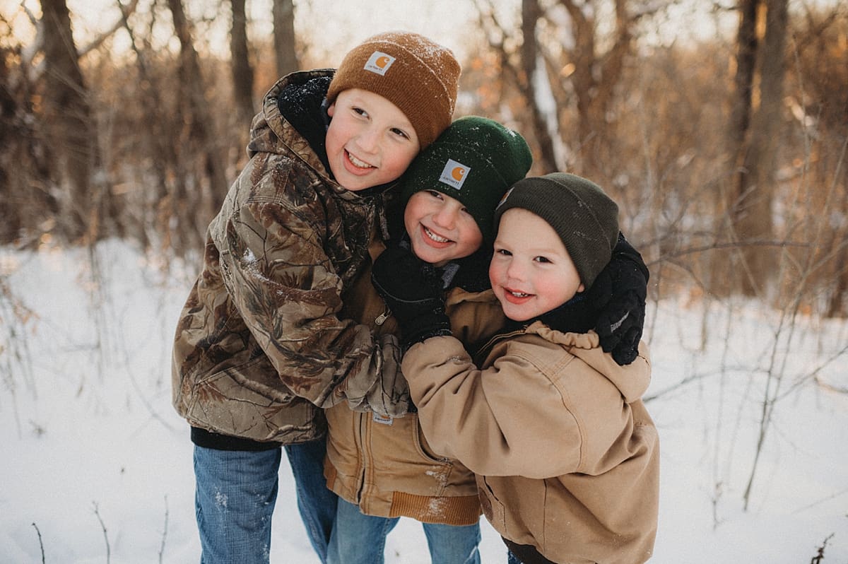 three hugging brothers in the winter