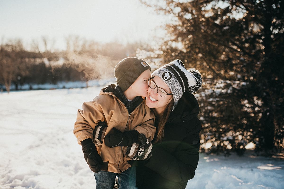 mom kisses during snowy family photo session in Lake Geneva